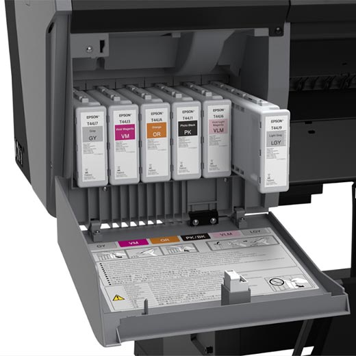 Close-up of the Epson SureColor P9570 44” Wide Printer’s open compartment showing seven Epson UltraChrome PRO12 Ink cartridges (GY, VM, VLM, OR, PK, Y, LGY) and printed panel instructions—ideal for pro photography.