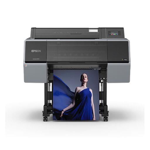 The Epson SureColor P7570 24” Wide Printer (SCP7570SE) uses UltraChrome PRO12 Ink to print a vibrant, high-quality poster of a woman in a flowing blue dress. The black and gray Epson printer stands on wheels against a plain white background.