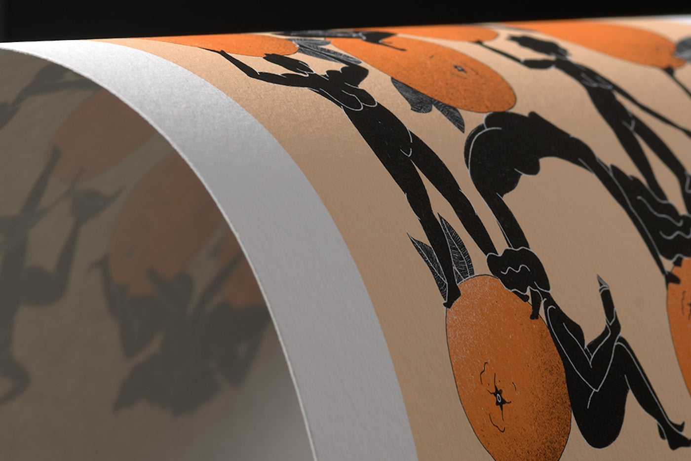 A close-up of a curved sheet of paper featuring black, ancient Greek-inspired figures and large orange circles, possibly representing fruit, on a beige background.