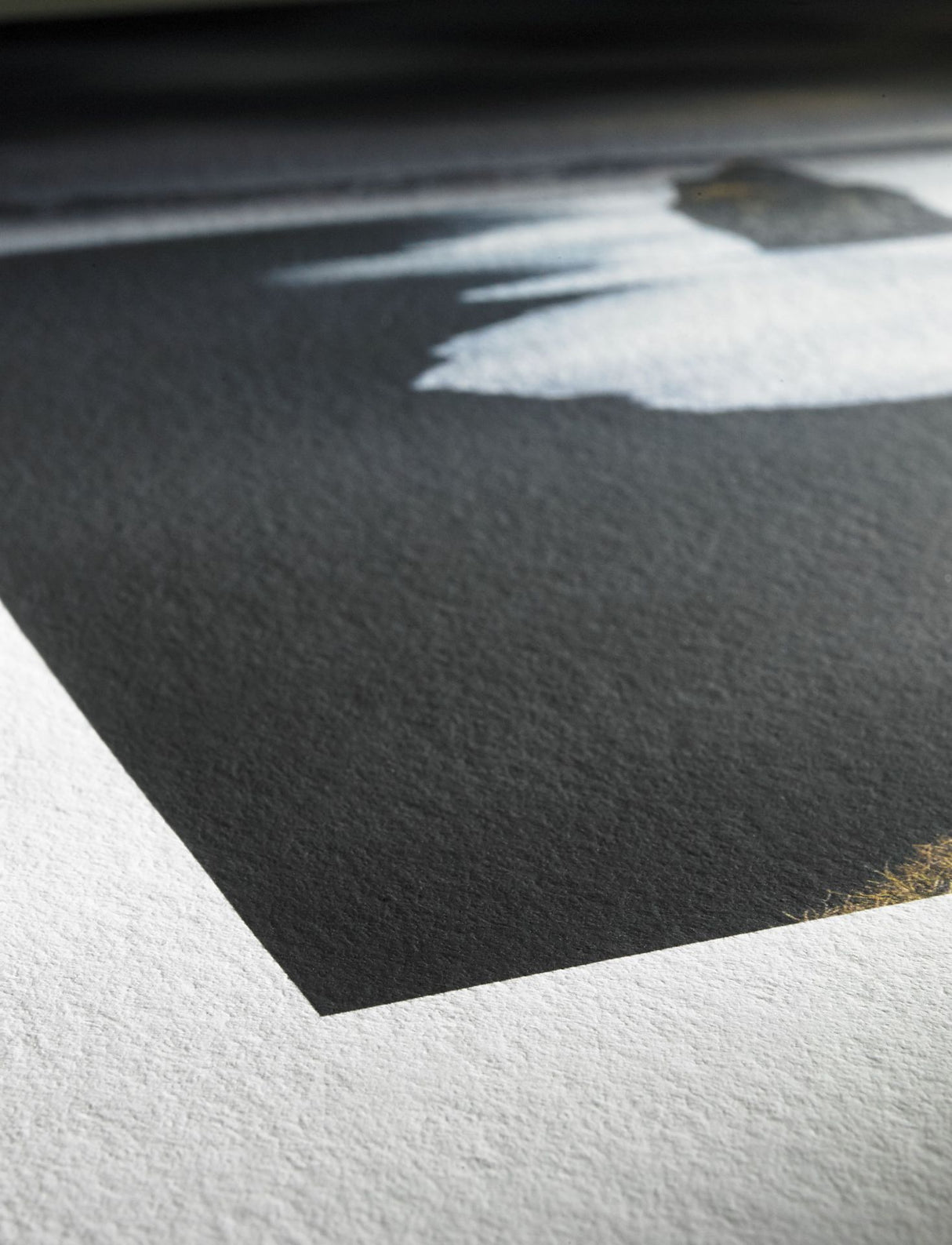 Close-up of Hahnemuhle’s Hahnemühle Photo Rag® Bright White cotton art paper featuring a printed sharp-edged black rectangle with blurred white and gray shapes, shown under natural light.
