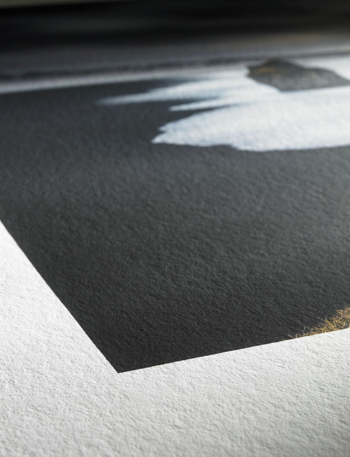 Close-up of Hahnemuhle’s Hahnemühle Photo Rag® Bright White cotton art paper featuring a printed sharp-edged black rectangle with blurred white and gray shapes, shown under natural light.
