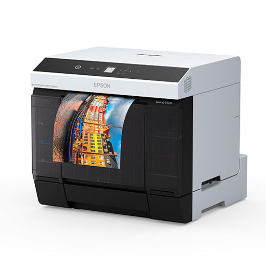 An Epson SureLab D1070DE Professional Minilab Photo Printer with Double-Sided Printing (SLD1070DE) prints a vibrant photo of waterfront buildings with reflections on a plain white background.