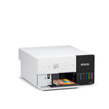 The Epson SureLab D570 Professional Minilab Photo Printer (SLD570SE) by Epson, a white small-format printer with a control panel and visible ink tanks, prints a vibrant photo on a plain white background.