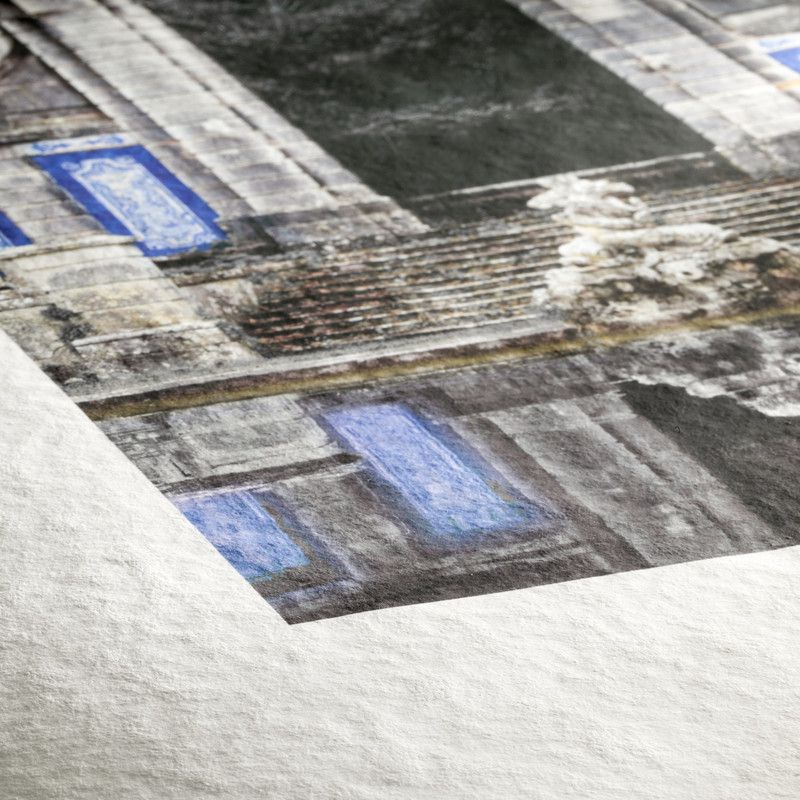 A close-up of a building print on Hahnemuhle Torchon paper reveals the rough texture, archival quality, and vivid colors of this premium Hahnemuhle product, with detailed stone steps and blue windows in focus.