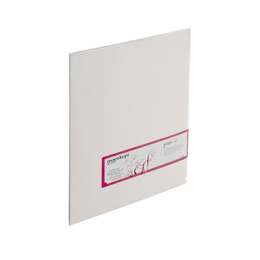 A single sheet of MOAB Moenkopi Washi Kozo 110—crafted with Kozo fibers—stands upright at an angle, displaying a white surface with a rectangular pink and white label on the lower right side.