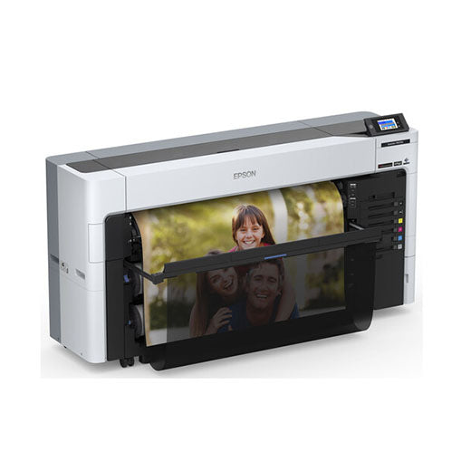 An Epson SureColor P8570DL 44-Inch Wide-Format Dual-Roll Printer with a high-capacity 1.6 L ink pack system prints a vibrant photo of smiling people, its control panel aglow and part of the image visible in the output tray.