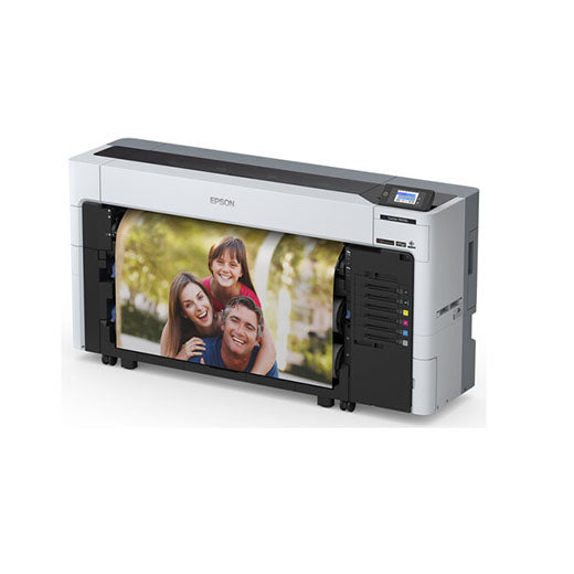 An Epson SureColor P8570DL 44-Inch Wide-Format Dual-Roll Printer with High-Capacity 1.6 L Ink Pack System prints a colorful outdoor photo of three smiling people; multiple ink packs are visible on the right side.