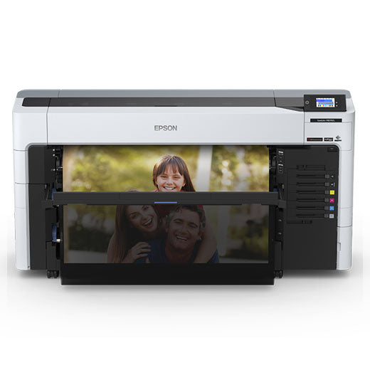 An Epson SureColor P8570DL 44-Inch Wide-Format Dual-Roll Printer with High-Capacity 1.6L Ink Pack System prints a vibrant photo of a smiling woman hugging a man, with another photo of a child above; its front panel and display are visible.