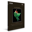 A box of Epson Cold Press Bright fine art paper by Epson displays a dynamic dancer in a green dress leaping on a black background. The packaging is black with white text and product details.