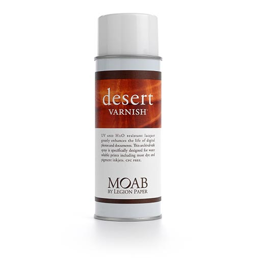 A 400 ml can of MOAB Desert Varnish Spray features a white cap, brown desert-themed label, and provides UV protection and water resistance to preserve prints and documents.