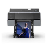 The Epson SureColor P7570 24” Wide Printer (SCP7570SE) uses UltraChrome PRO12 Ink to print a vibrant, high-quality poster of a woman in a flowing blue dress. The black and gray Epson printer stands on wheels against a plain white background.